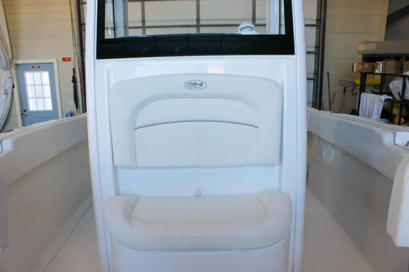 Slide: The Image of 2025 Sea Hunt Ultra 239 SE boat interior with white seating in a garage. - 48
