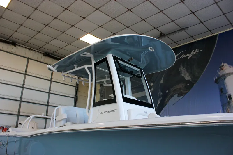 Slide: The Image of 2025 Sea Hunt Ultra 239 SE boat in showroom, featuring sleek design and modern canopy. - 5