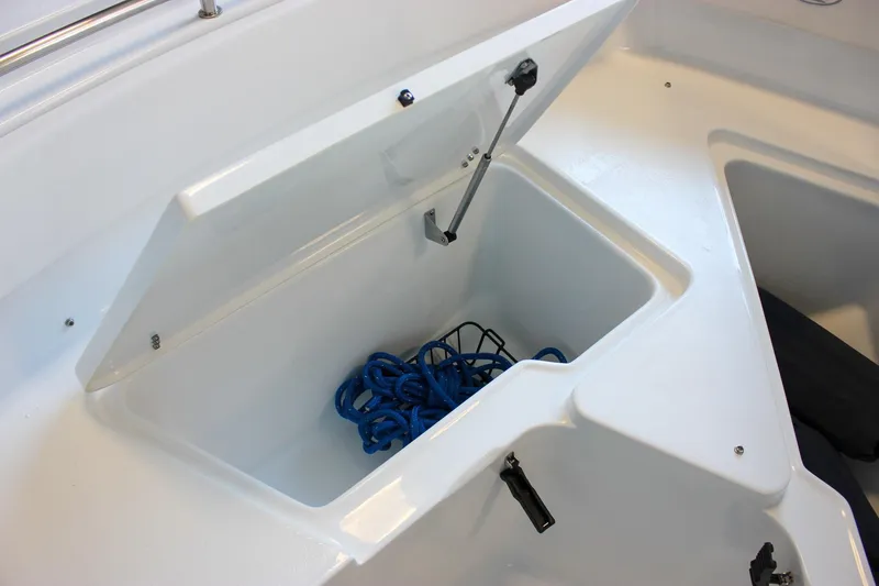 Slide: The Image of Storage compartment on 2025 Sea Hunt Ultra 239 SE boat with blue rope inside. - 53