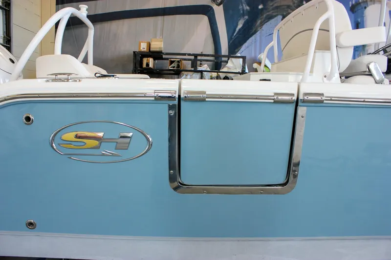 Slide: The Image of 2025 Sea Hunt Ultra 239 SE boat with blue side panel and SH logo. - 55