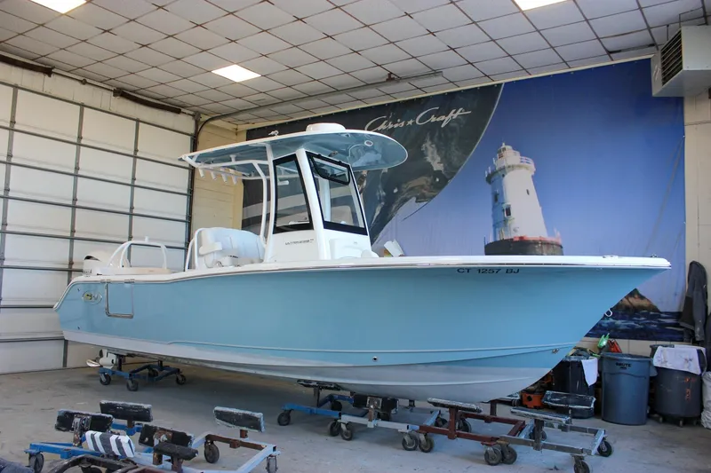 Slide: The Image of 2025 Sea Hunt Ultra 239 SE boat in indoor storage, light blue hull. - 57
