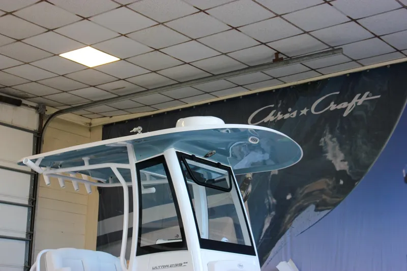 Slide: The Image of 2025 Sea Hunt Ultra 239 SE boat displayed indoors with Chris-Craft backdrop. - 58