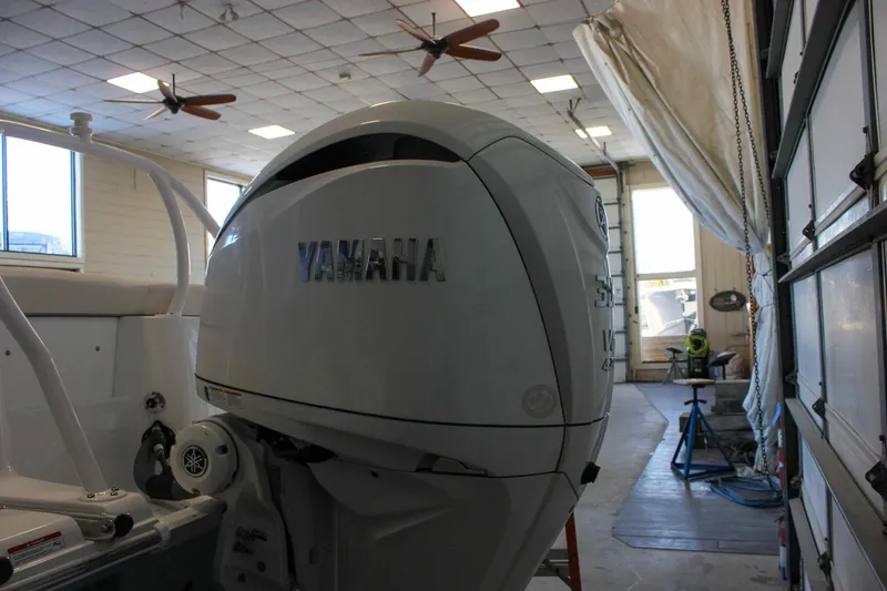 Slide: The Image of 2025 Sea Hunt Ultra 239 SE with Yamaha outboard engine in a garage. - 6