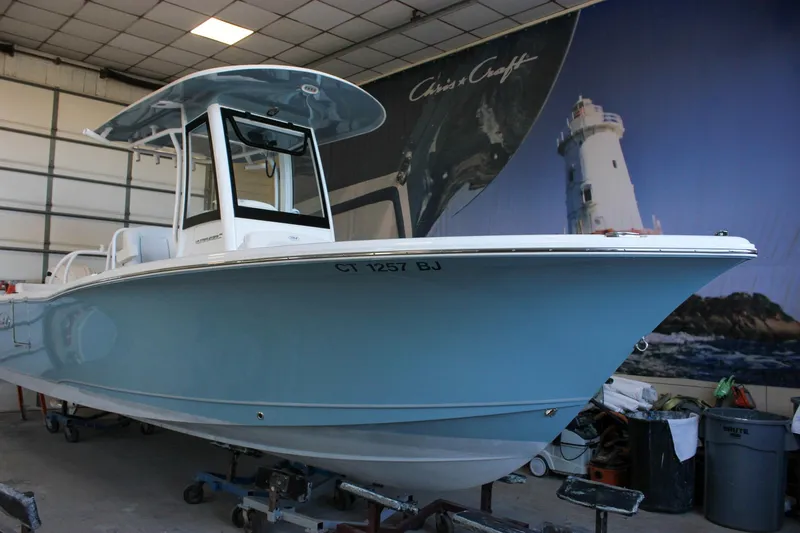 Slide: The Image of 2025 Sea Hunt Ultra 239 SE boat in a showroom with nautical backdrop. - 60