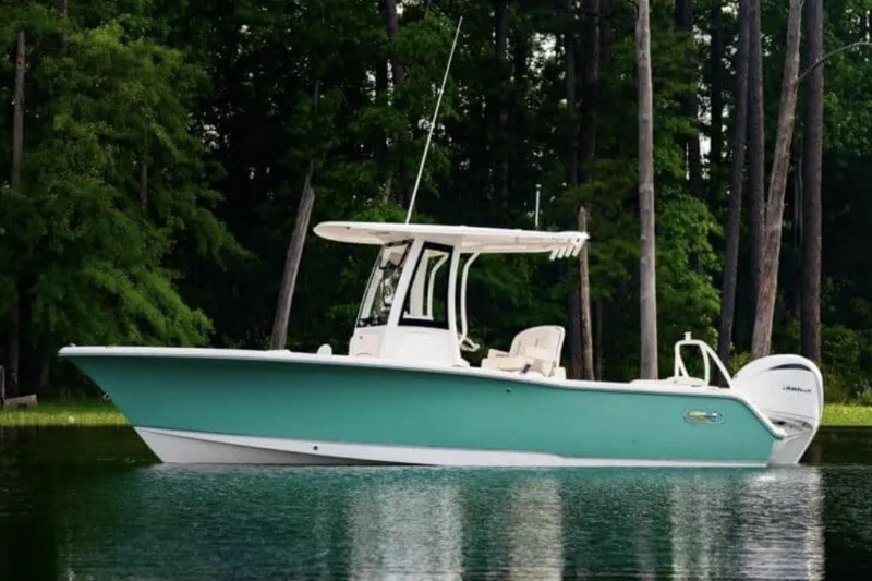 Slide: The Image of Manufacturer Provided Image: 2025 Sea Hunt Ultra 239 SE boat on calm water, surrounded by lush trees. - 64