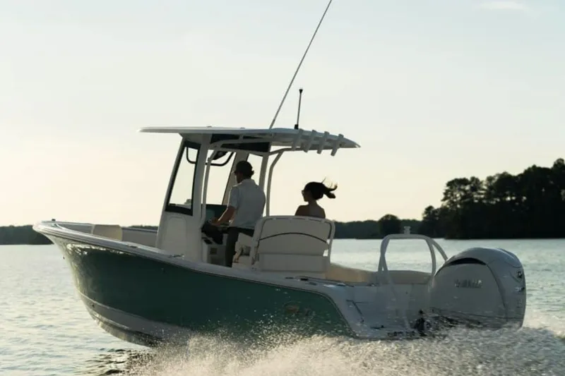 Slide: The Image of Manufacturer Provided Image: 2025 Sea Hunt Ultra 239 SE boat cruising on a serene lake at sunset. - 65