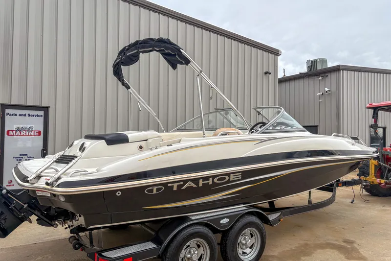The Image of 2012 Tahoe 216 WT boat on trailer near service building. - 0