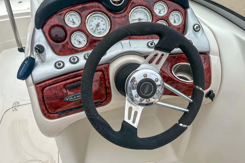 Slide: The Image of Steering wheel and dashboard of 2012 Tahoe 216 WT boat with gauges and controls. - 8