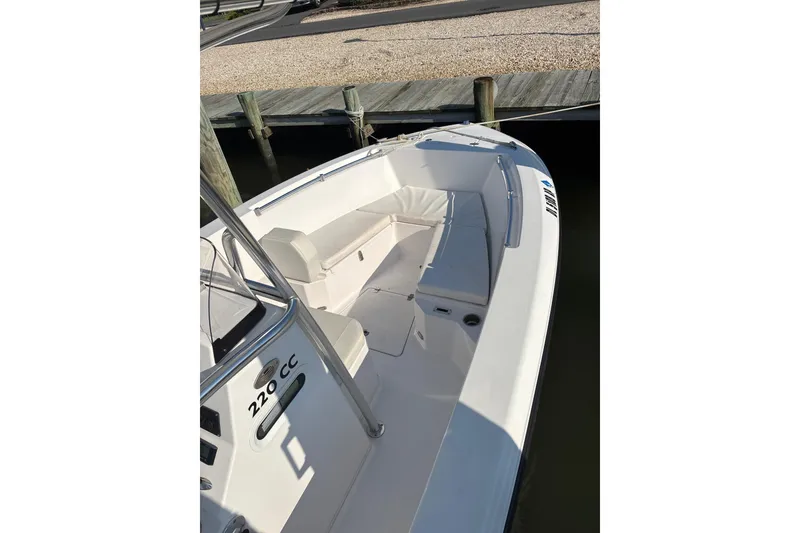 Slide: The Image of 2023 Aquasport 22CC boat with white seating, docked at a marina. - 8