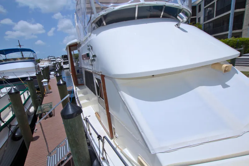 Slide: The Image of 1987 Jefferson 42 Sundeck yacht docked at marina under clear blue sky. - 11