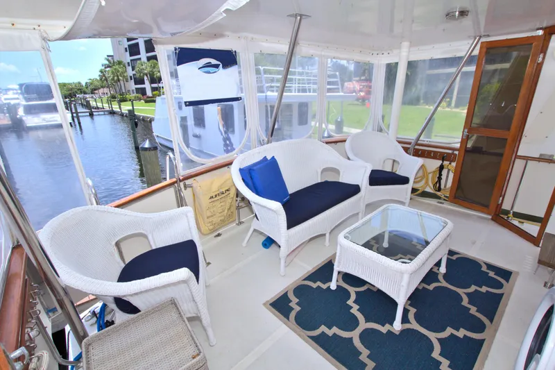 Slide: The Image of 1987 Jefferson 42 Sundeck yacht with wicker seating and glass table on deck. - 12