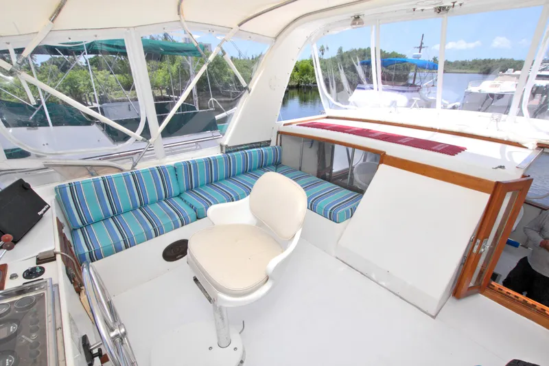 Slide: The Image of 1987 Jefferson 42 Sundeck yacht interior with striped seating and white chair. - 18