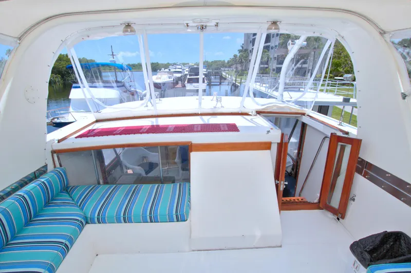 Slide: The Image of 1987 Jefferson 42 Sundeck yacht interior with striped seating and marina view. - 19