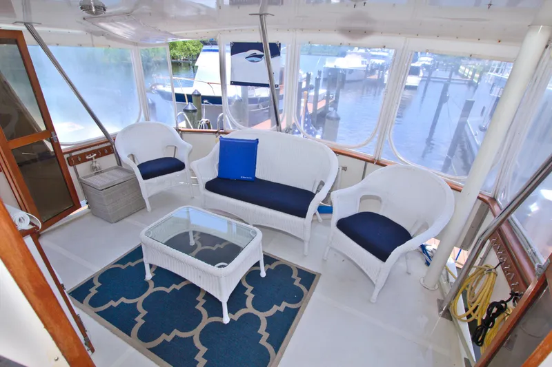 Slide: The Image of 1987 Jefferson 42 Sundeck yacht interior with wicker furniture and marina view. - 21