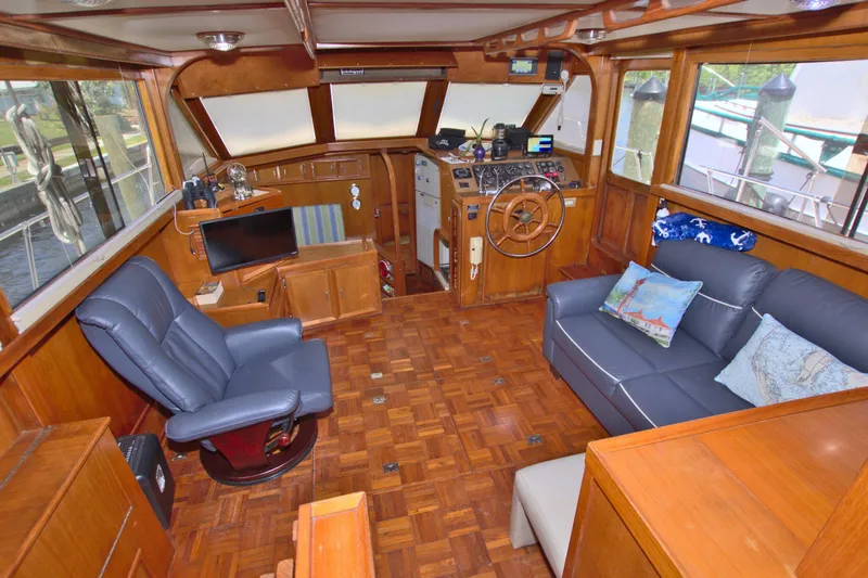 Slide: The Image of 1987 Jefferson 42 Sundeck interior with wood paneling, seating, and helm station. - 23