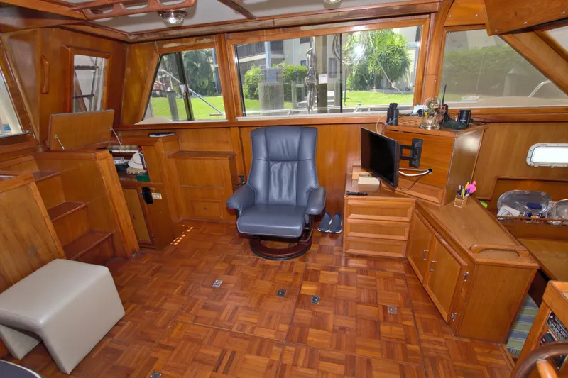 Slide: The Image of 1987 Jefferson 42 Sundeck interior with wood paneling, blue chair, and TV setup. - 24