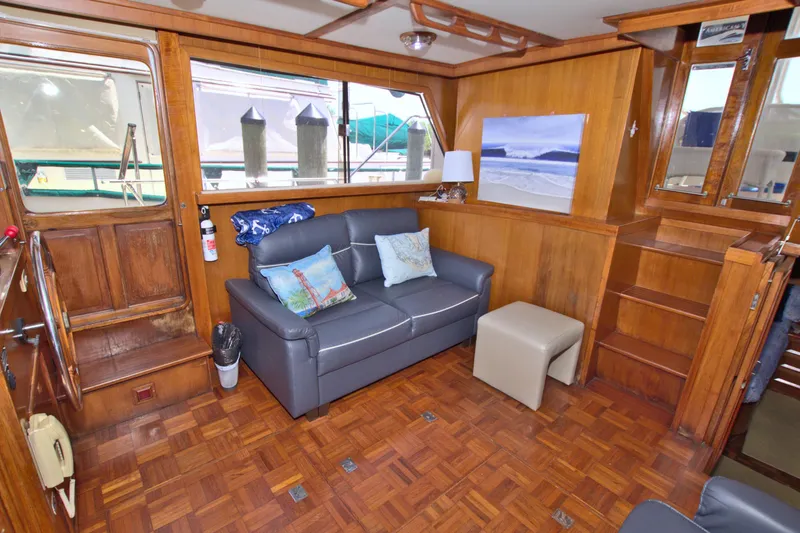 Slide: The Image of Interior of 1987 Jefferson 42 Sundeck yacht with wood paneling and cozy seating area. - 26