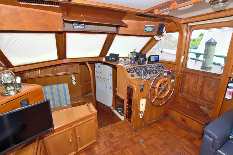 Slide: The Image of 1987 Jefferson 42 Sundeck yacht interior with wooden helm, steering wheel, and navigation equipment. - 28