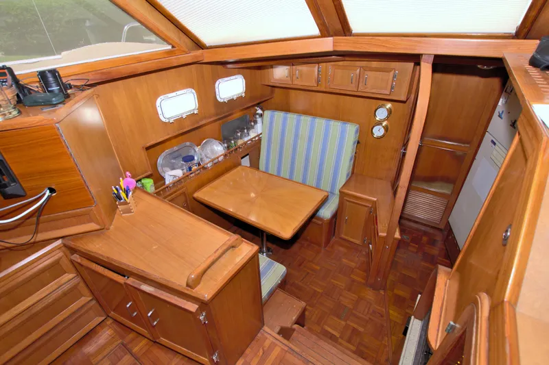 Slide: The Image of 1987 Jefferson 42 Sundeck interior with wood finish, dining area, and striped seating. - 31