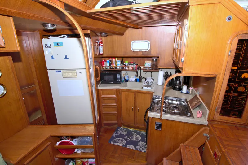 Slide: The Image of 1987 Jefferson 42 Sundeck yacht kitchen with wooden cabinetry and modern appliances. - 32