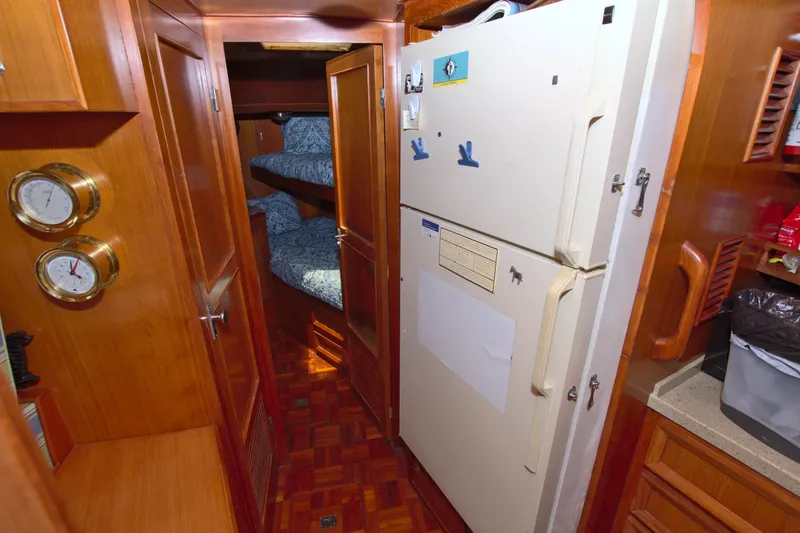 Slide: The Image of Interior of 1987 Jefferson 42 Sundeck yacht with wood paneling and refrigerator. - 34