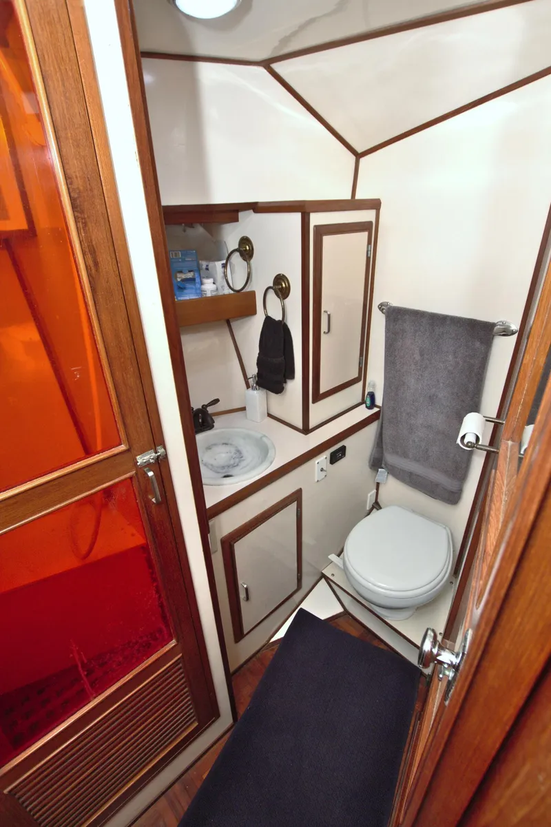 Slide: The Image of 1987 Jefferson 42 Sundeck yacht bathroom with sink, toilet, and storage cabinets. - 37