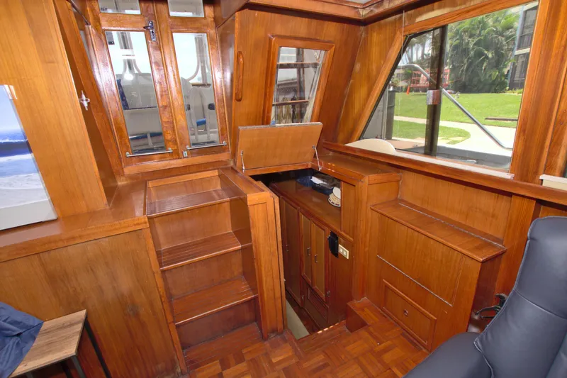 Slide: The Image of 1987 Jefferson 42 Sundeck interior with wooden cabinetry and windows, showcasing classic nautical design. - 43