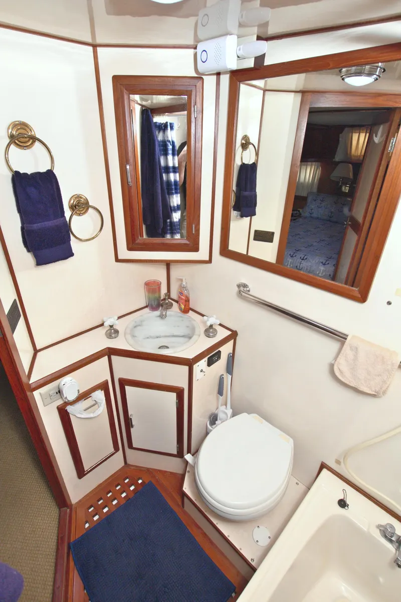 Slide: The Image of 1987 Jefferson 42 Sundeck yacht bathroom with sink, toilet, and mirror. - 48