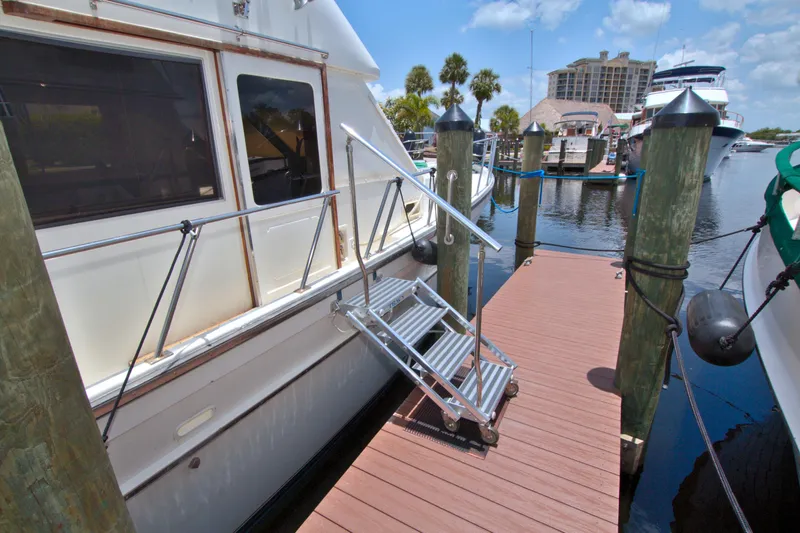 Slide: The Image of 1987 Jefferson 42 Sundeck yacht docked with boarding ladder, marina view. - 5