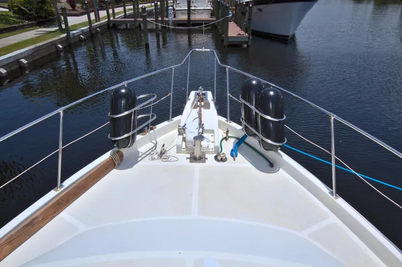 Slide: The Image of Bow view of 1987 Jefferson 42 Sundeck yacht docked in a serene marina. - 7