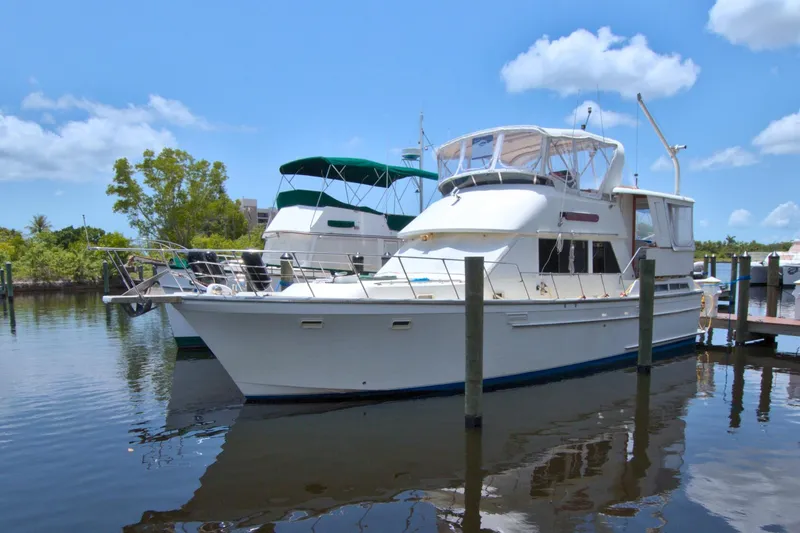 Slide: The Image of 1987 Jefferson 42 Sundeck yacht docked in a serene marina setting. - 73