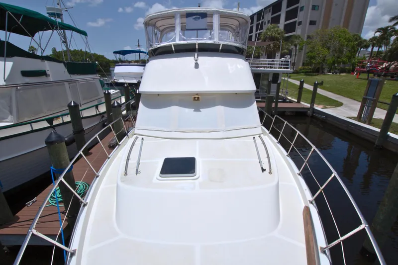 Slide: The Image of 1987 Jefferson 42 Sundeck yacht docked at marina, viewed from bow under clear sky. - 8