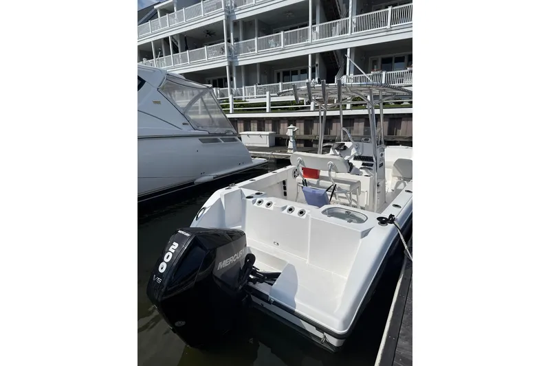 Slide: The Image of 2023 Aquasport 22CC boat docked with Mercury outboard engine. - 4