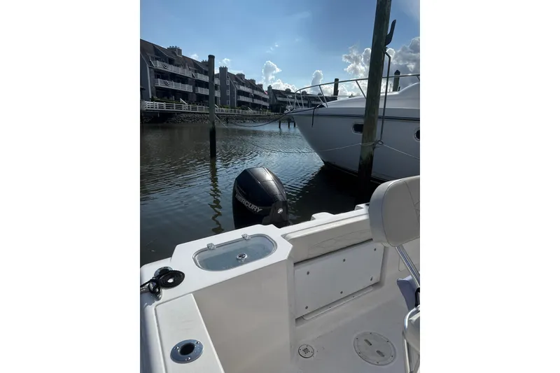 Slide: The Image of 2023 Aquasport 22CC boat docked in marina with Mercury outboard motor. - 9