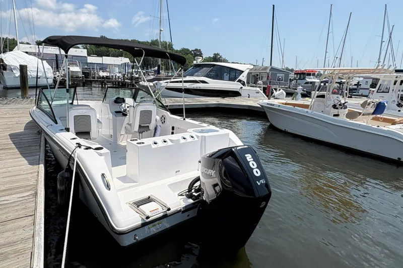 Slide: The Image of 2023 Aquasport 22CC boat docked with Mercury 200 V6 engine, marina background. - 4