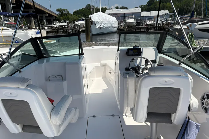 Slide: The Image of 2023 Aquasport 22CC boat interior with helm, seating, and marina background. - 6