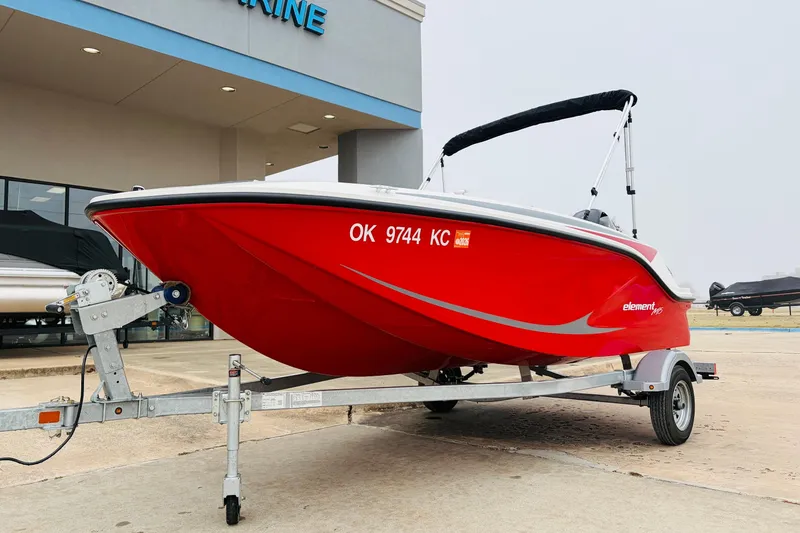 Slide: The Image of 2023 Bayliner Element M15 boat in vibrant red on a trailer outside a dealership. - 3