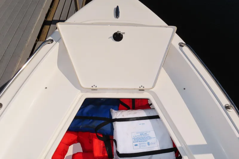 Slide: The Image of 2018 Key West 1720 Center Console boat with open storage compartment and life jackets. - 18
