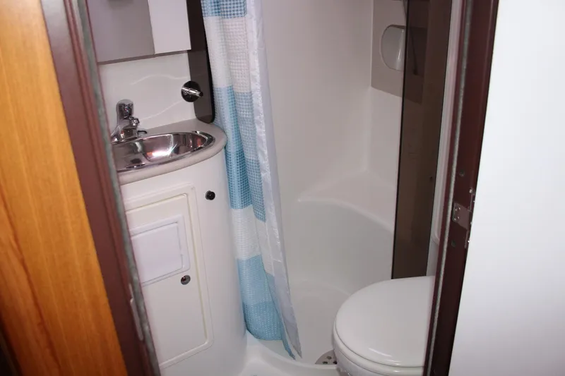 Slide: The Image of Compact bathroom in a 2011 Catalina 445 sailboat, featuring a sink, toilet, and shower. - 10
