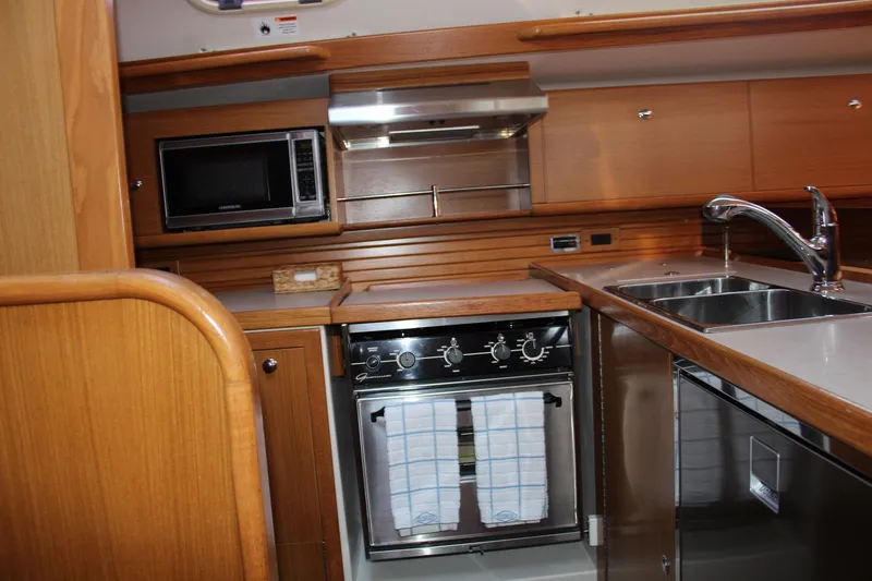 Slide: The Image of 2011 Catalina 445 yacht kitchen with microwave, oven, and stainless steel sink. - 13