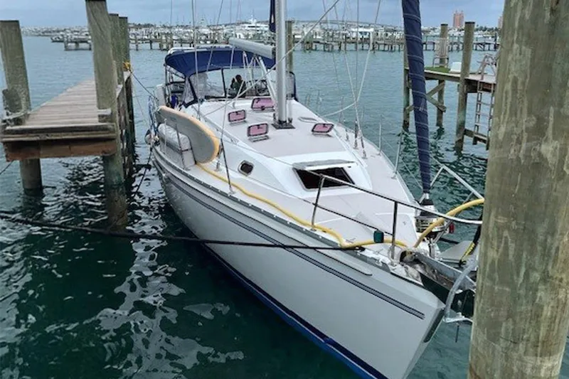 Slide: The Image of 2011 Catalina 445 sailboat docked at a marina, surrounded by calm water. - 26
