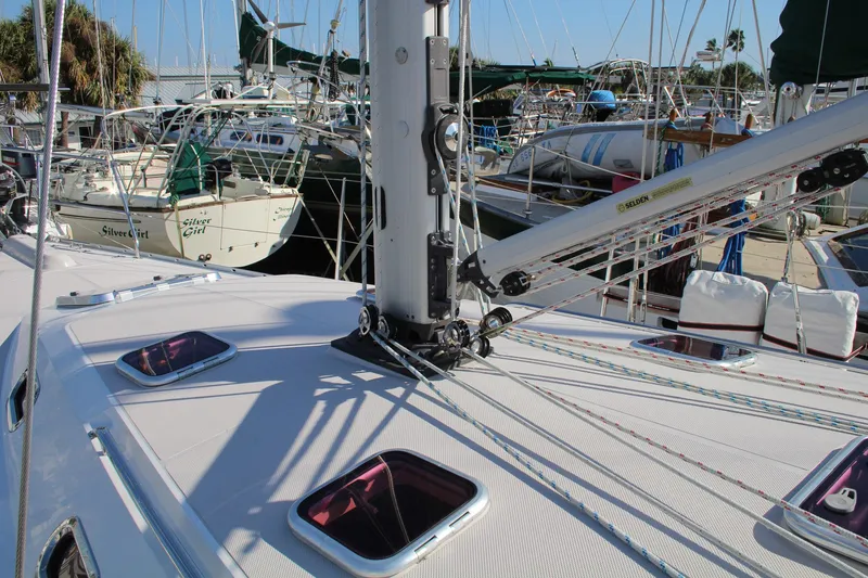 Slide: The Image of 2011 Catalina 445 sailboat deck with rigging and hatches in a marina setting. - 35