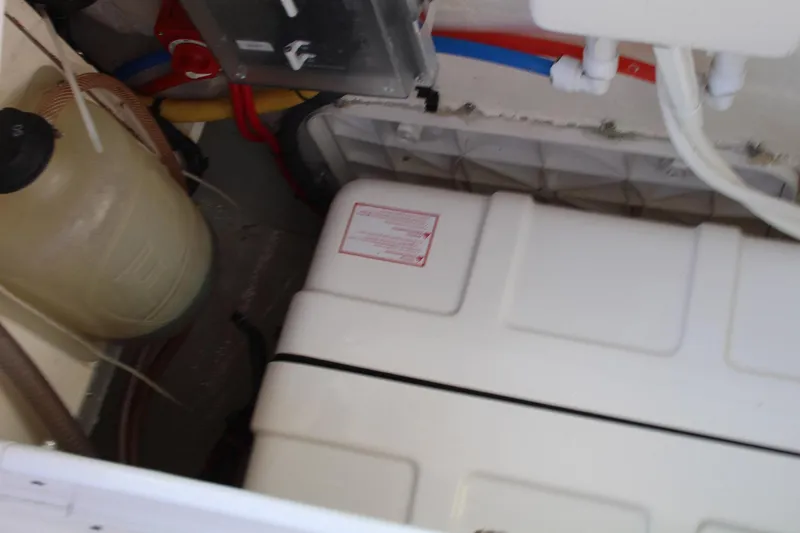 Slide: The Image of Engine compartment of a 2011 Catalina 445 sailboat, showing tanks and hoses. - 47