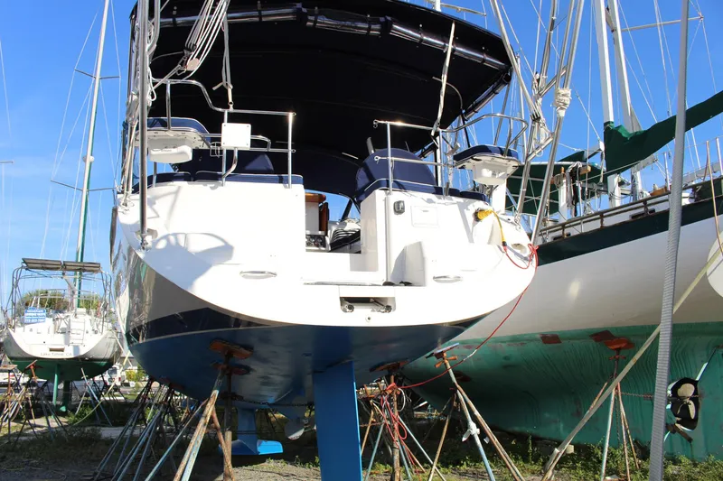 Slide: The Image of 2011 Catalina 445 sailboat on stands in a boatyard, surrounded by other vessels. - 54