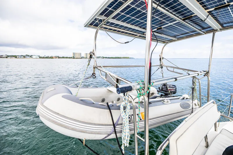 Slide: The Image of Solar-powered Gemini Legacy 35 catamaran with dinghy, 2014 model, on calm waters. - 21