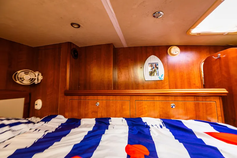 Slide: The Image of Cozy cabin interior of 2014 Gemini Legacy 35 with striped bedding and wooden paneling. - 34