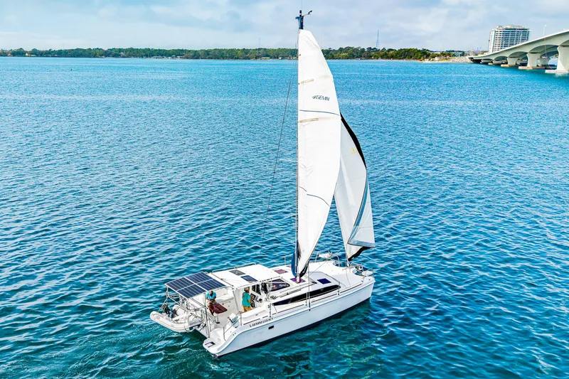 Slide: The Image of Sailing catamaran Gemini Legacy 35, 2014 model, cruising on clear blue waters near a bridge. - 6