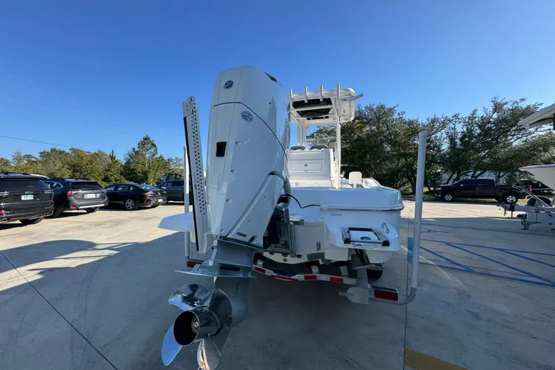 Slide: The Image of 2026 Caymas 26 HB boat with powerful outboard motor, parked outdoors under clear blue sky. - 13