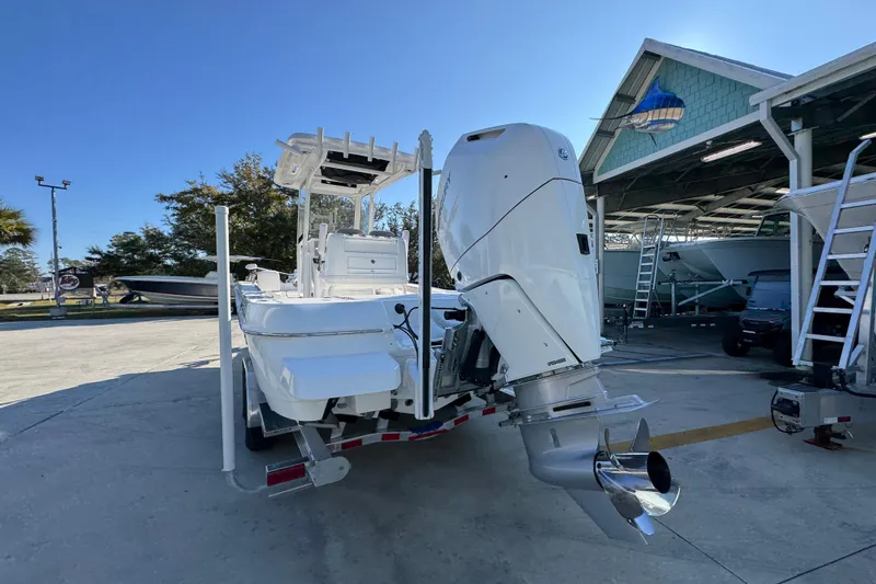 Slide: The Image of 2026 Caymas 26 HB boat with powerful outboard motor, parked outdoors. - 15