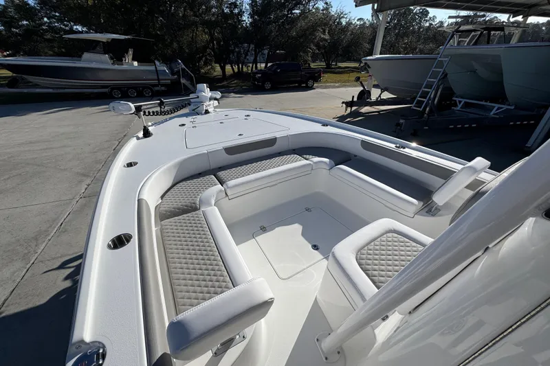 Slide: The Image of 2026 Caymas 26 HB boat with spacious seating and modern design in a marina setting. - 20